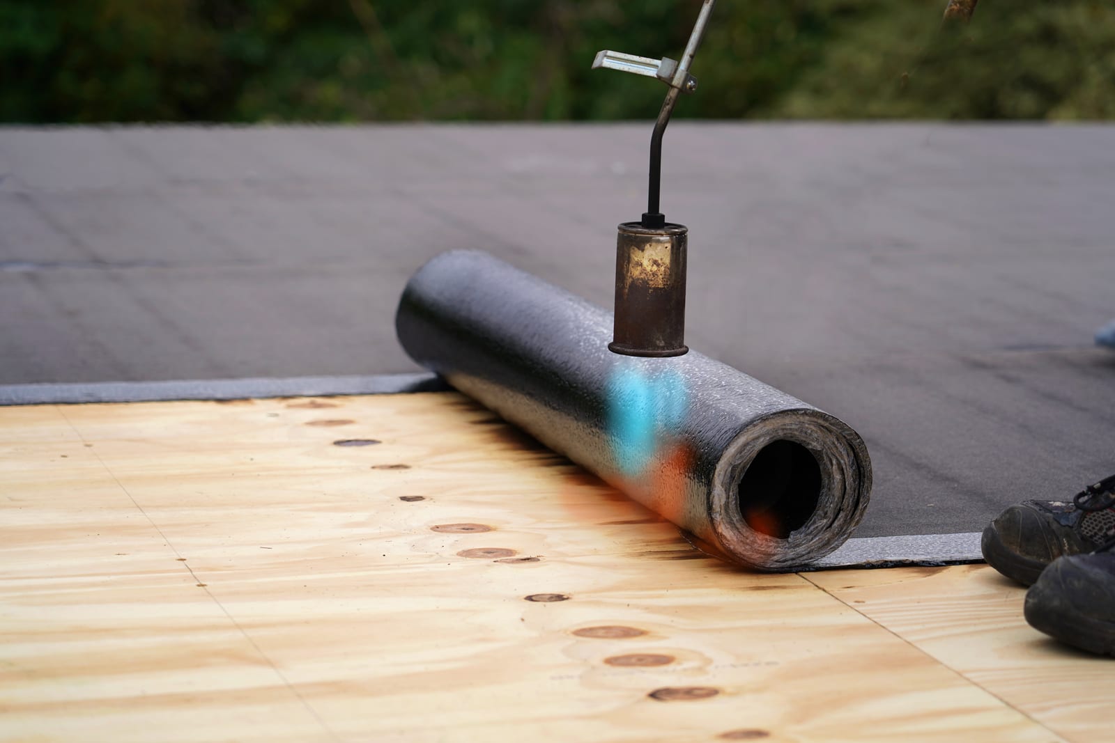 Torch-on felt flat roofing being installed